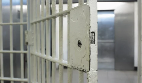 Preso tenta fugir, mas entala entre as grades da cela